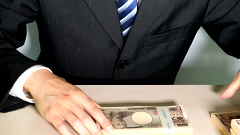 A businessman piling up stacks of cash Stock Footage 334780128