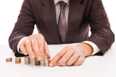 Businessman Placing Coin Over Stack At Desk Stock Photos