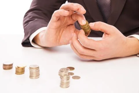 Businessman Placing Coin Over Stack At Desk Foto stock