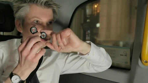 Businessman playing with a fidget spinner in the back of a taxi cab Stock Footage 85615448