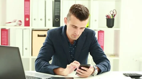 Businessman Playing games in the office using a smartphone and wins Stock Footage