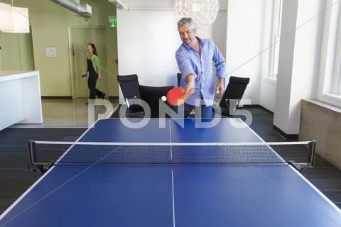 Businessman Playing Table Tennis In Office