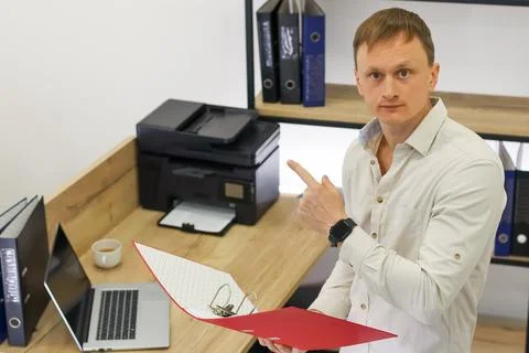 Businessman pointing at document in red folder Stock Photos
