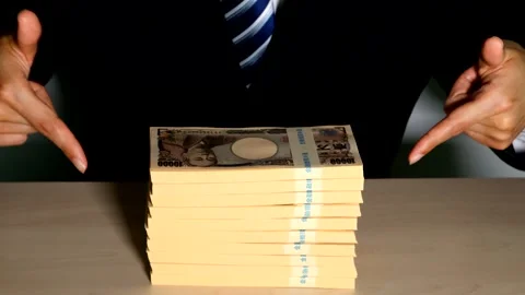 A businessman points to a pile of banknotes. Stock Footage 334760296
