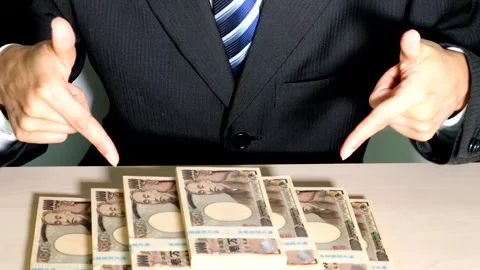 A businessman points to a pile of banknotes. Stock Footage 334761834