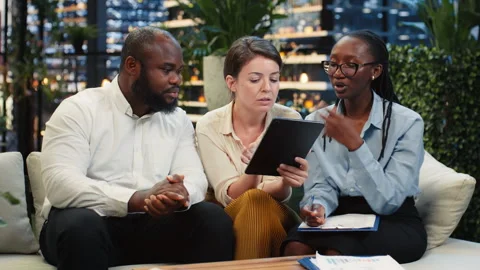 Businessman points to tablet screen during rooftop lounge workspace presentation Stock Footage 345164887