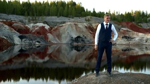 Businessman posing against the backdrop of a man-made hilly landscape Stock-Footage 132795531