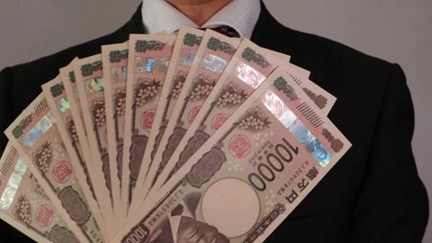 A businessman posing with many new 10,000 yen bills Stock Footage 325692178