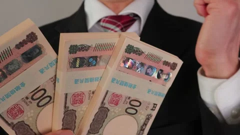 A businessman posing with a wad of bills 動画素材 325691710