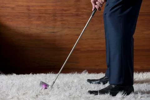 Businessman practicing golf in office Stock Photos