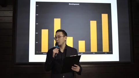 Businessman presenting report using microphone and tablet in conference hall Stock Footage 293780273