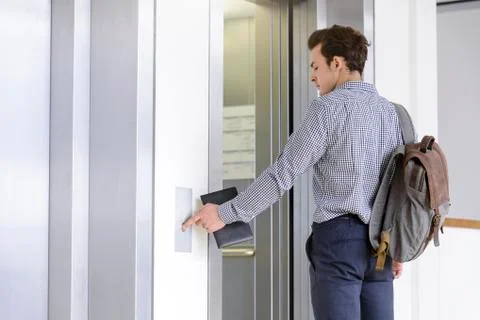 Businessman pressing button to open elevator doors Foto stock