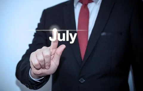 Businessman pressing button on virtual screen July button - concept Stock Photos