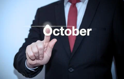 Businessman pressing button on virtual screen October button - concept Stock Photos