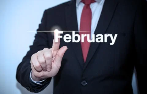 Businessman pressing button on virtual screen February button - concept Stock Photos