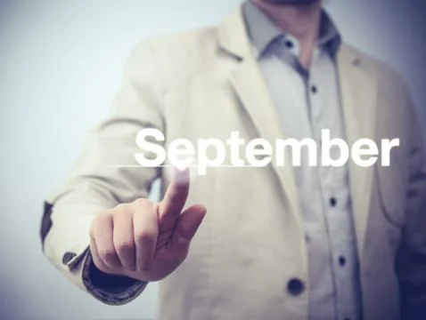 Businessman pressing button on virtual screen September button - concept Stock Photos