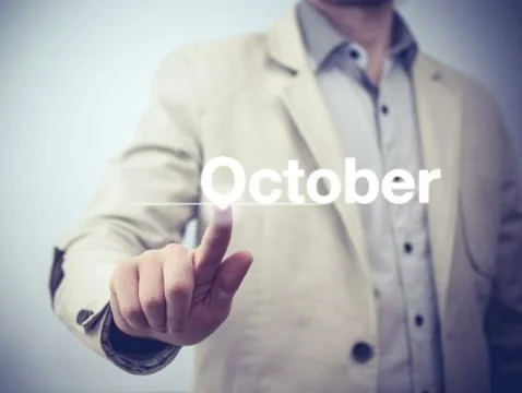 Businessman pressing button on virtual screen October button - concept Stock Photos