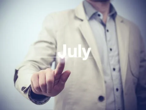 Businessman pressing button on virtual screen July button - concept Stock Photos