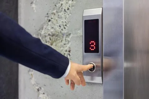 Businessman pressing elevator button in modern building Foto stock