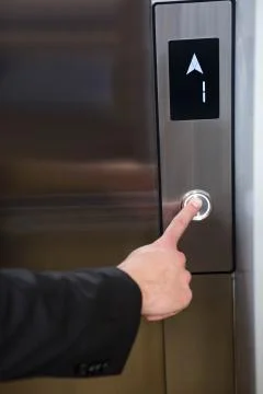 Businessman pressing elevator button Stockfoto's