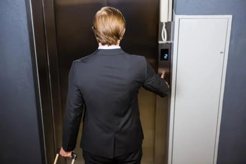 Businessman pressing elevator button Fotos de archivo