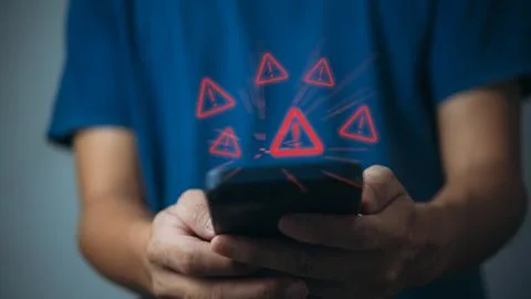 Businessman programmer, developer using smartphone with triangle caution wa.. Stock Photos