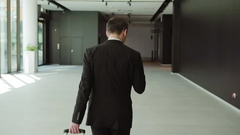 Businessman pulling suitcase and texting on phone 스톡 동영상 108680556
