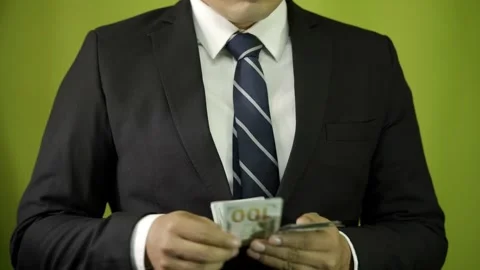 A businessman pulls dollars out of his suit pocket and counting bills  Stock Footage 275351328