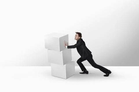 Businessman pushing a stack of cubes Stockfoto's