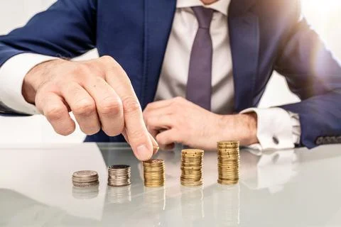 Businessman Put Coin To Stack Of Coins. Conceptual photo. Foto stock