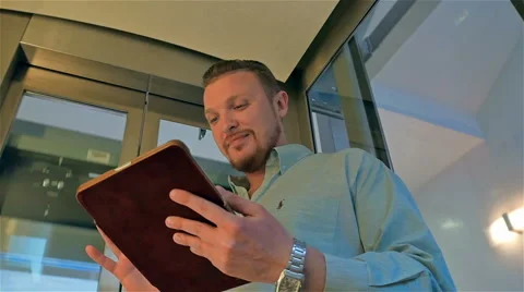 Businessman raised in an elevator with a tablet computer in his hands Vídeos de archivo 49968006
