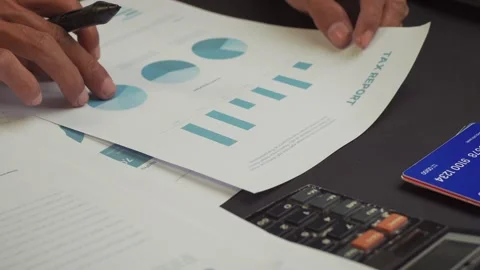 A businessman is reading and analyzing his company's tax report documents. .. Stock Footage 308869738