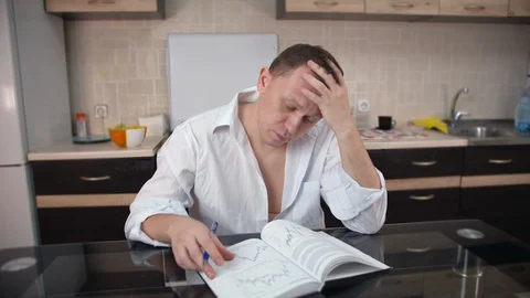 A businessman is reading a book with graphs Stock Footage 129883306