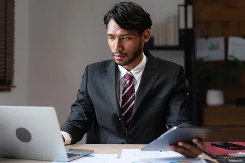 Businessman reading data on tablet to typing on laptop while analyzing stra.. Stock Photos