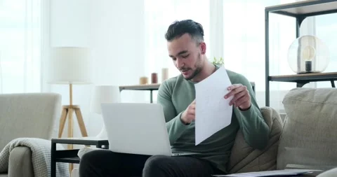 Businessman reading document while doing video conference on laptop Stock Footage 156470450