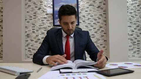 Businessman Reading Documents with Graphs Stock Footage 85637626