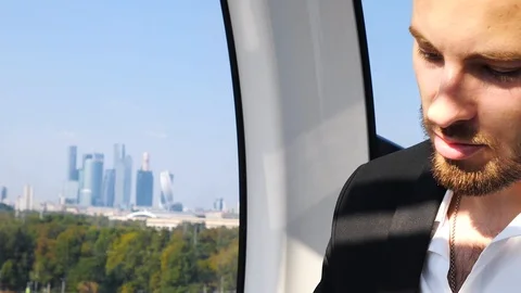 Businessman reading documents while sitting in the VIP cabin cable car Stock Footage 102832062