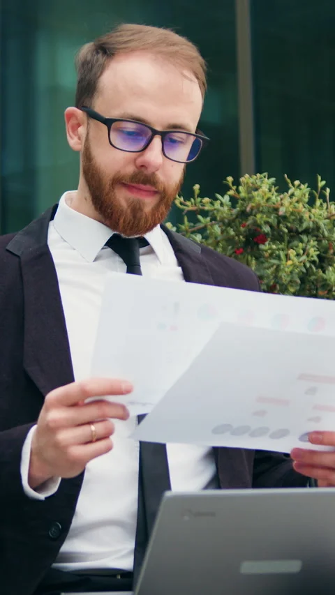 Businessman reading documents while sitting on bench outdoor. Man working on lap Stock Footage 330256901