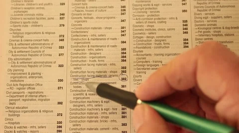 Businessman is reading, marking and making notes in the phonebook Stock Footage 47029016
