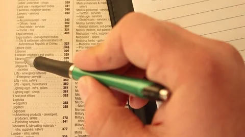 Businessman is reading, marking and making notes in the phonebook and notebook Stock Footage 47029097