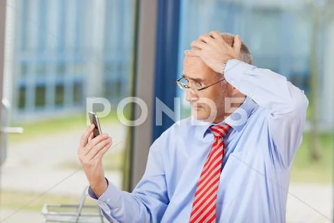 Businessman reading message on mobile phone Stock Photos