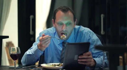Businessman reading news on tablet computer during dinner at home HD Stock Footage 41967904
