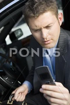 Businessman Reading Text Message On His Cell Phone Stock Photos