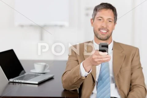 Businessman reading text message on mobile phone Stock Photos
