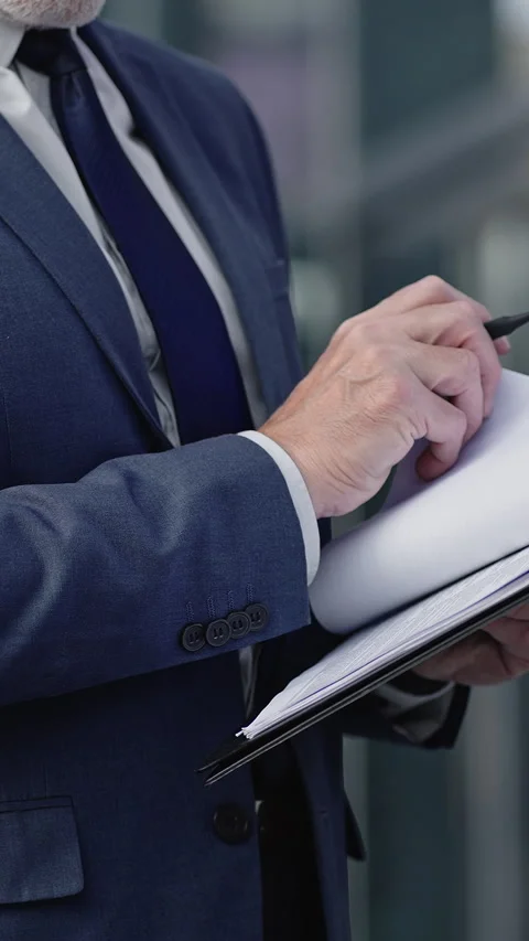 Businessman reads project plan on clipboard making edits Stock Footage 329785447