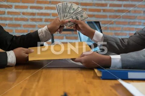 Businessman receiving envelope with money. Man giving cash (banknote) to busi Stock-Fotos