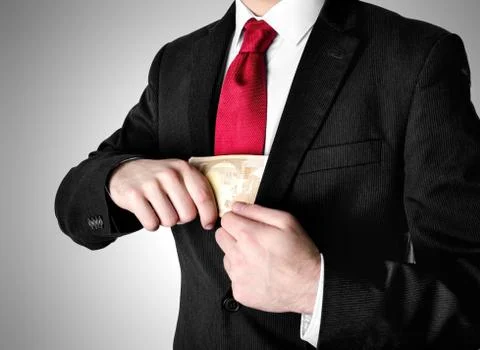 Businessman with red tie puting stack of fifty euro bills into his suit. Stock Photos