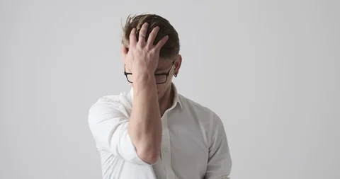 Businessman regretting wrongdoing over white background Stock Footage 121228396