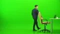 The businessman relaxing at the table on the green background 4k or 4k+ Resolution