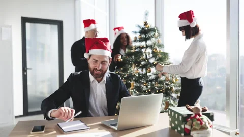 Businessman in a Santa hat with pen making notes on draft of paper document Stockbeeldmateriaal 256905723